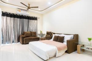 a bedroom with a bed and a couch and chairs at Indigo Studio by JadeCaps 1BHK New Town Kolkata in kolkata