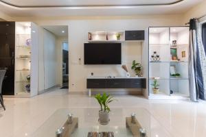a living room with a flat screen tv on a wall at Indigo Studio by JadeCaps 1BHK New Town Kolkata in kolkata