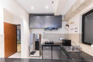 a kitchen with a sink and a counter top at Indigo Studio by JadeCaps 1BHK New Town Kolkata in kolkata +48 photos