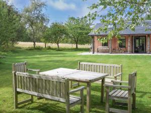 a picnic table and two benches in a yard at Relugas Mill in Forres