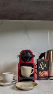 a red coffee maker sitting on a counter with two cups at Terra Blue Suites - Nefeli in Kalyves