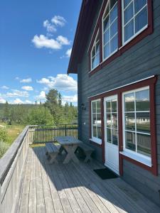 a wooden deck with a picnic table and a building at Fjällstuga Vemdalsskalet in Vemdalen