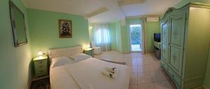 a bedroom with a large white bed and green walls at Casa Oasa Boutique rooms Pool near Koper in Koper