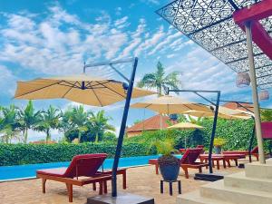 a group of chairs and umbrellas next to a pool at Bon Bini Residence Apart-Hotel - Pool, Fast WiFi, Security, Backup Power in Kampala