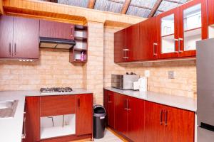 a kitchen with wooden cabinets and a sink at Falcon Lodge Bela Bela in Bela-Bela