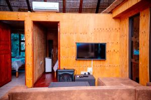 a living room with a fireplace and a tv on a wall at Falcon Lodge Bela Bela in Bela-Bela