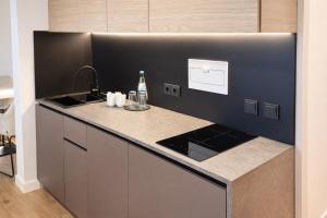 a kitchen with a sink and a counter top at BEELiving Augsburg in Augsburg