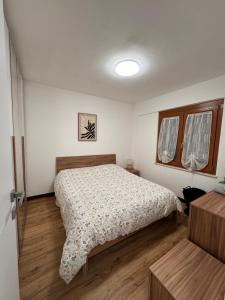 a small bedroom with a bed and a window at Campaegli House in Campaegli