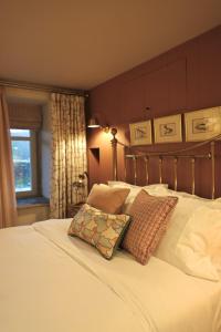 a bedroom with a white bed with a pillow on it at Lock Keepers Cottage at Salterhebble in Exley