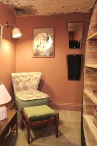 a living room with a chair and a tv at Lock Keepers Cottage at Salterhebble in Exley
