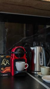 a red coffee maker sitting on a counter with a cup at Terra Blue Suites - Dimitra in Kalyves