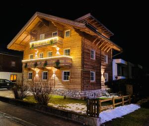 a wooden house with lights on the side of it at Lodge Rose's Heart in Bramberg am Wildkogel