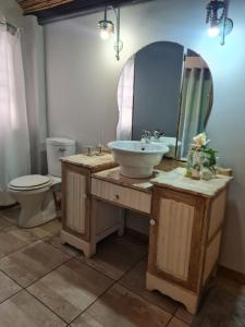 a bathroom with a sink and a toilet and a mirror at Little Rock Resort in Ladybrand +34 photos