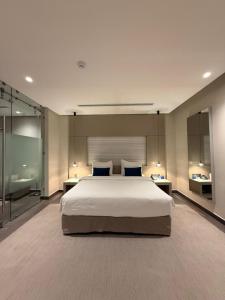 a large bedroom with a large bed and two mirrors at Rafa Hotel Apart in Riyadh