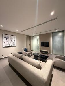 a living room with couches and a flat screen tv at Rafa Hotel Apart in Riyadh