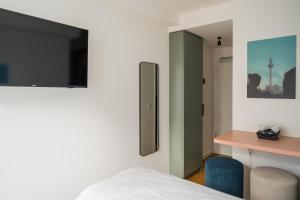 a bedroom with a bed and a desk and a mirror at Homaris Nolli Studios in Berlin