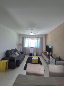 a living room with a couch and a tv at Elis Praia e Aconchego in Iguaba Grande