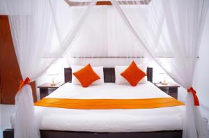 a bedroom with a white bed with orange pillows at Zeleny Apartments in Nugegoda