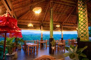 a restaurant with tables and chairs and a view at Green Coco Suite by AGATA in Nusa Penida