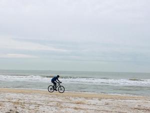 eine Person, die am Strand Fahrrad fährt in der Unterkunft Millsight in Uitgeest