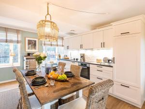 a kitchen with a wooden table and chairs at Prora - Apartment mit Strandnähe - Aquarius in Binz