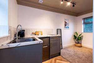 a kitchen with a sink and a counter top at The Coach House, Gatwick in Horley +13 photos