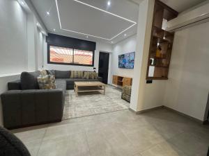 a living room with a couch and a table at Appartement sur villa in Temara +7 photos