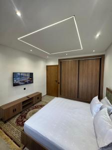 a bedroom with a large bed and a flat screen tv at Appartement sur villa in Temara
