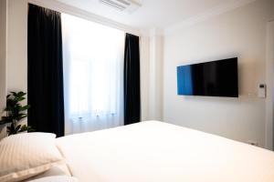 a bedroom with a bed and a tv and a window at Ghica Boutique Suites in Vaslui