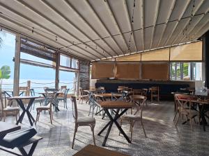 a restaurant with tables and chairs and a piano at The Archipelago Waterfront in Zanzibar City