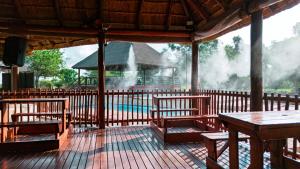a pavilion with benches and a pool in the background at Falcon Lodge Bela Bela in Bela-Bela