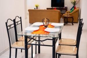 a glass table with two chairs and a dining room at Zeleny Apartments in Nugegoda