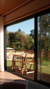a large glass window with a wooden table outside at Quinta Sra do Carmo in Ferreira do Zêzere +56 photos