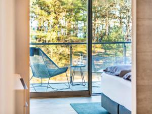 a room with a bed and a chair on a balcony at Prora - Ferienwohnung mit Waschmaschine - Sunrise in Binz