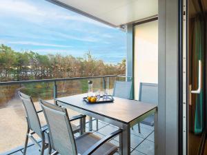 a table and chairs on a balcony with a view at Prora - Ferienwohnung mit Waschmaschine - Sunrise in Binz