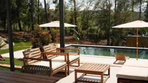 a patio with chairs and umbrellas next to a pool at Quinta Sra do Carmo in Ferreira do Zêzere