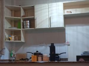 a kitchen with white cabinets and a counter top at Victorian Haven in Eldoret