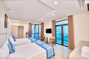 a hotel room with two beds and a television at Tuấn Đạt Luxury FLC Sầm Sơn in Sầm Sơn