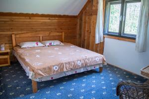 a bedroom with a bed in a wooden room at Pensiunea Padina in Bran