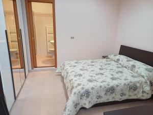 a bedroom with a bed with a floral comforter at Corso Ovidio - Casa vacanze in Sulmona