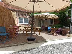 a patio with tables and chairs and an umbrella at Emporium in Lobbes