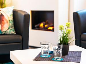 two glasses on a table in front of a fireplace at Prora - Ferienwohnung mit Sauna - Meer geht immer in Binz