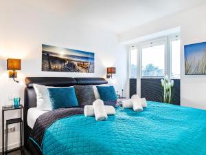 a bedroom with a blue bed with two white towels at Prora - Ferienwohnung mit Sauna - Meer geht immer in Binz