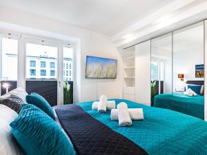 a bedroom with a blue bed with blue pillows at Prora - Ferienwohnung mit Sauna - Meer geht immer in Binz +20 photos