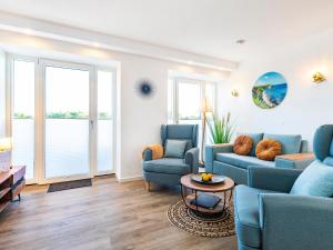 a living room with blue couches and a table at Prora - Ferienwohnung mit Waschmaschine - Meeresrauschen Dachterrasse in Binz +18 photos