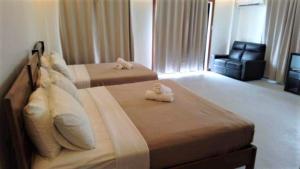a hotel room with two beds and a chair at Anapuro Elnido in El Nido