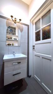 a bathroom with a white sink and a door at Dom Pod Złotym Bażantem in Kobiela
