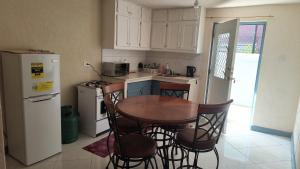 a kitchen with a table and chairs and a refrigerator at Harmony Guest House in Bridgetown