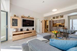 a living room with a couch and a tv at Prora - Wohnung mit Terrasse - Proras Strandhaus in Binz