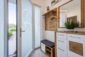 a kitchen with white cabinets and a sliding glass door at Prora - Wohnung mit Terrasse - Proras Strandhaus in Binz +16 photos